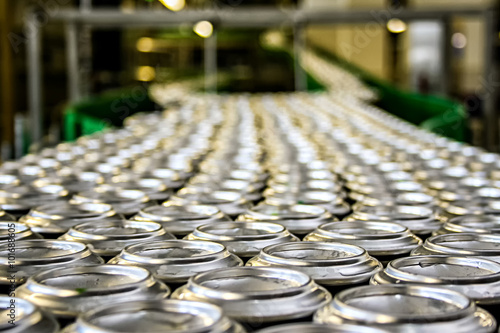 Thousands of shiny aluminum cans on conveyor line