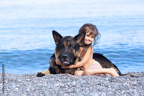 girl sitting on the bank with a dog