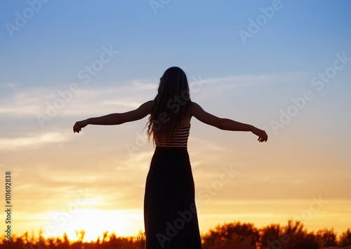 Silhouette of a beautiful girl  over sunset