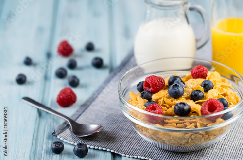 Healthy breakfast cereal with berries, milk and orange juice