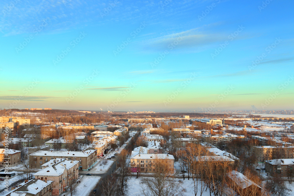 Residential area with buildings in snow at sunny winter evening