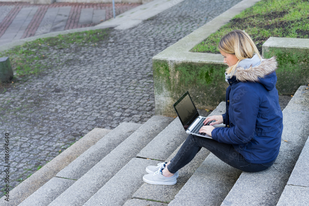 Fotografie studentin arbeitet mit dem laptop vor der uni