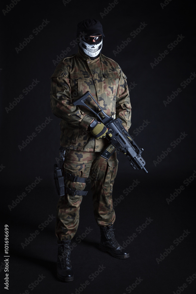 Anti terrorist dressed in camouflage, holding a gun, looking at camera Anti terrorist dressed in camouflage, holding a gun, looking at camera