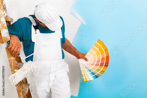 painter  with paintroller showing a color palette photo