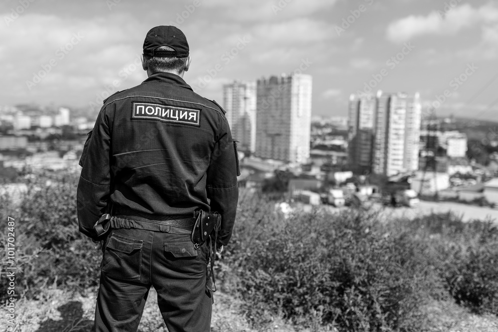 Detail of a police officer. Selective focus with shallow depth of field. Black and white toning. Detail of a police officer. Selective focus with shallow depth of field. Black and white toning.