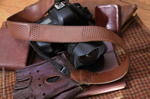 Photo camera with brown leather belt and other leather accessories