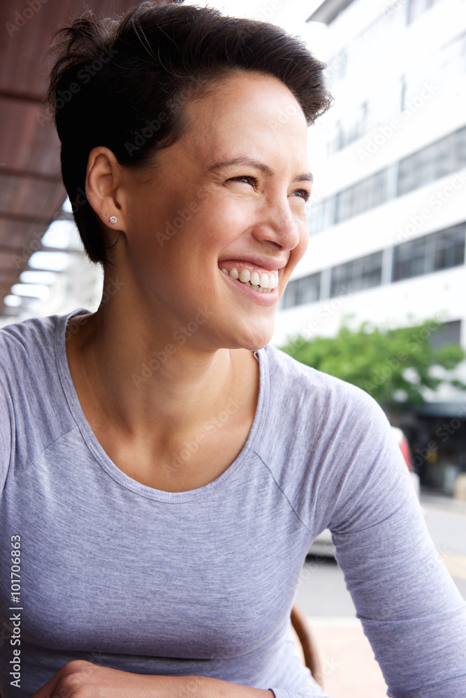 Smiling young woman with short hair smiling in the city Smiling young woman with short hair smiling in the city