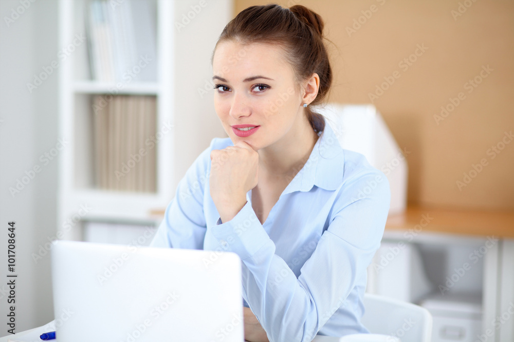 Young business woman working on laptop in office. Successful business concept. Young business woman working on laptop in office. Successful business concept.