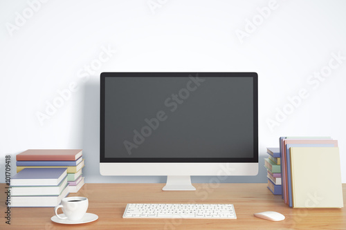Blank black computer screen with keyboard, cup of coffee and boo