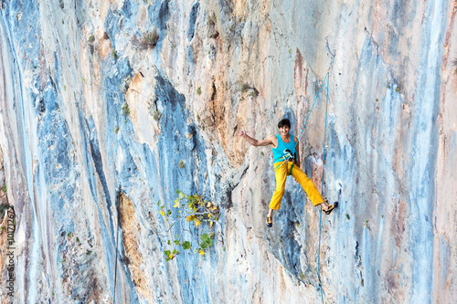 Smiling male Rock Climber descending on Rope with Okey hand sign