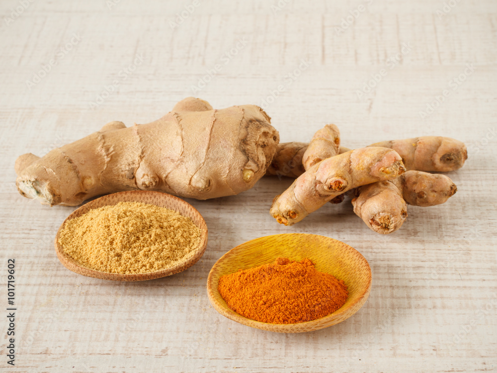 Ginger , turmeric powder and root on a table