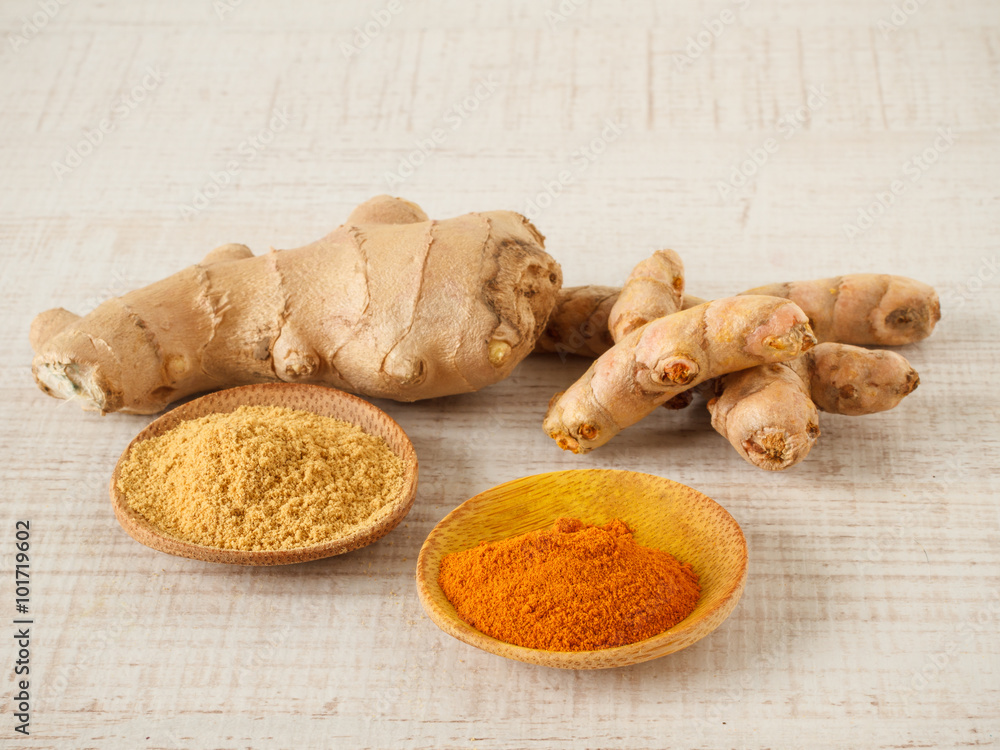 Ginger , turmeric powder and root on a table Ginger , turmeric powder and root on a table