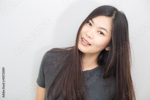 Bautiful asian girl smiling on gray background studio © themorningglory