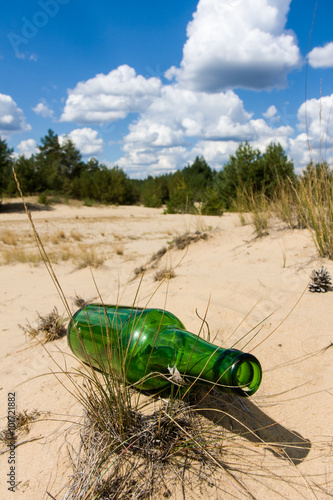 lost green bottle in sand