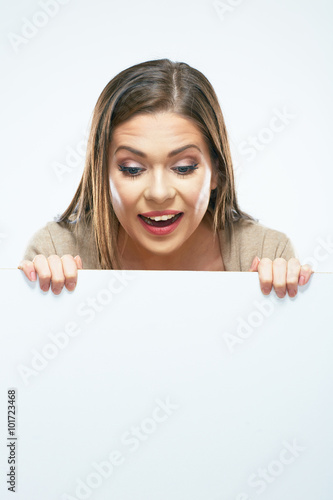 Woman looks out from behind white blank sign board.