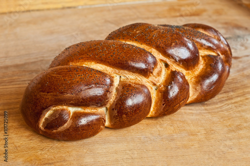 challah lying on a wooden table photo