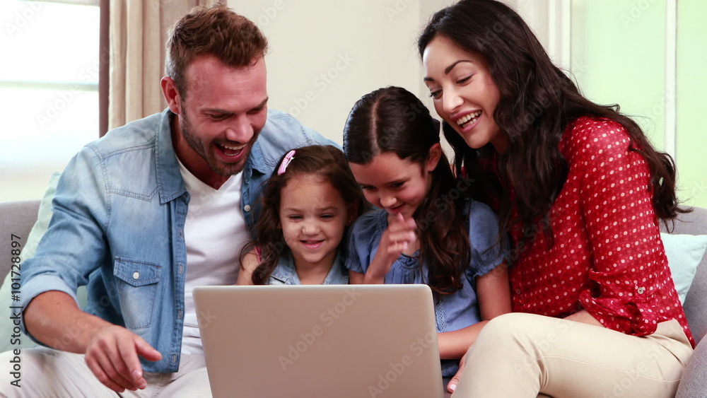 Happy family using laptop on sofa Happy family using laptop on sofa