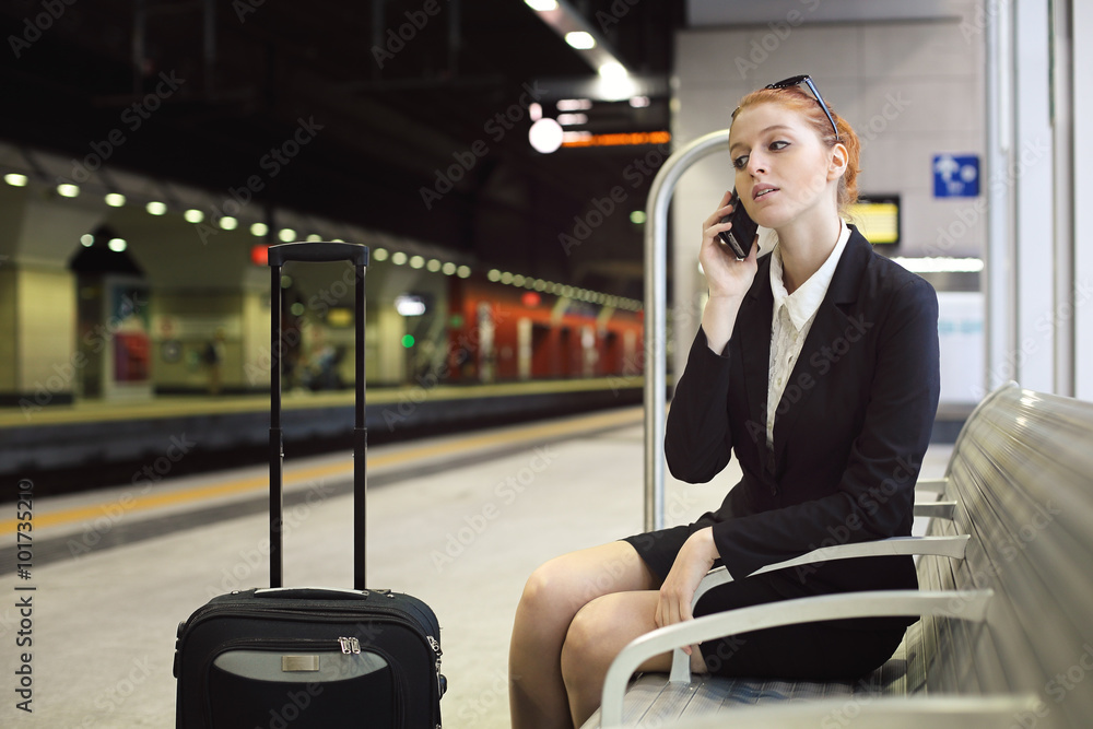 Fotografie Beautiful manager with cellphone at train station