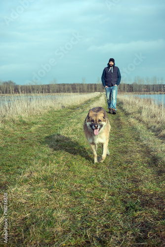 Mann geht mit seinem Hund spazieren © Kitty