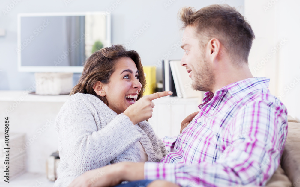 Attractive couple cuddling on the couch at home in the living room Attractive couple cuddling on the couch at home in the living room