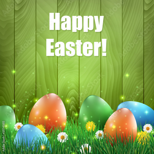Easter eggs and grass with a green wooden background.