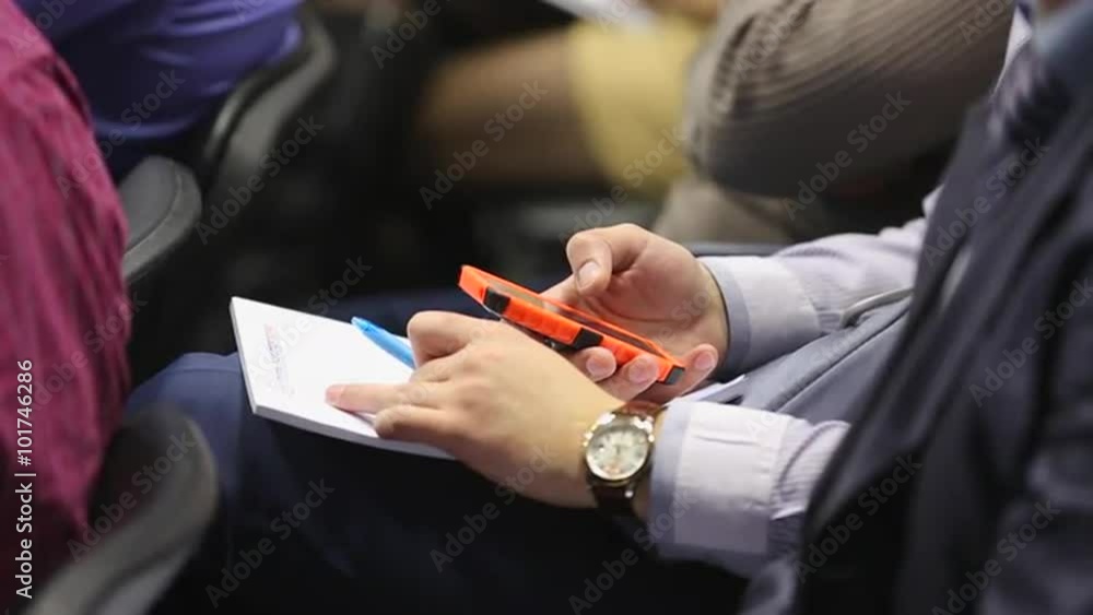 Man with phone touch screen at educational business conference Man with phone touch screen at educational business conference