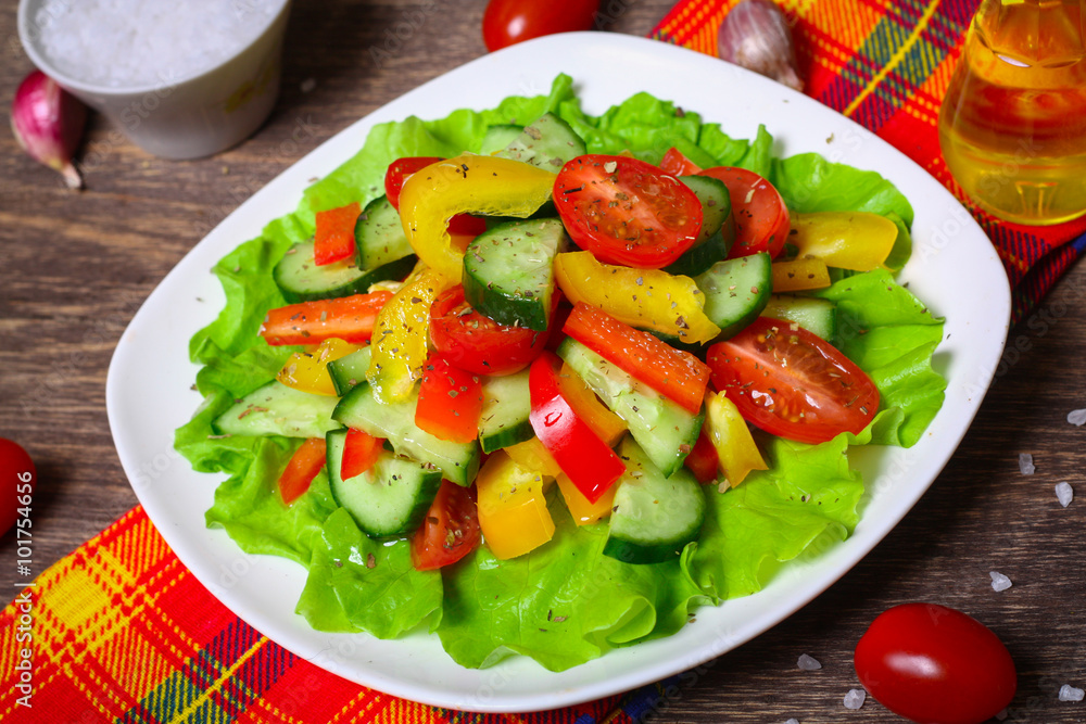 Helpful Fresh Salad of cucumbers, tomatoes, pepper and lettuce dressed with olive oil.