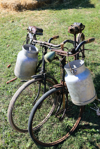 two rusty bicycles for the transport of milk in the bin of alumi photo