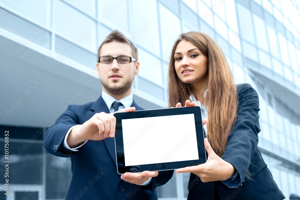 Successful young business people are holding a tablet, standing Successful young business people are holding a tablet, standing