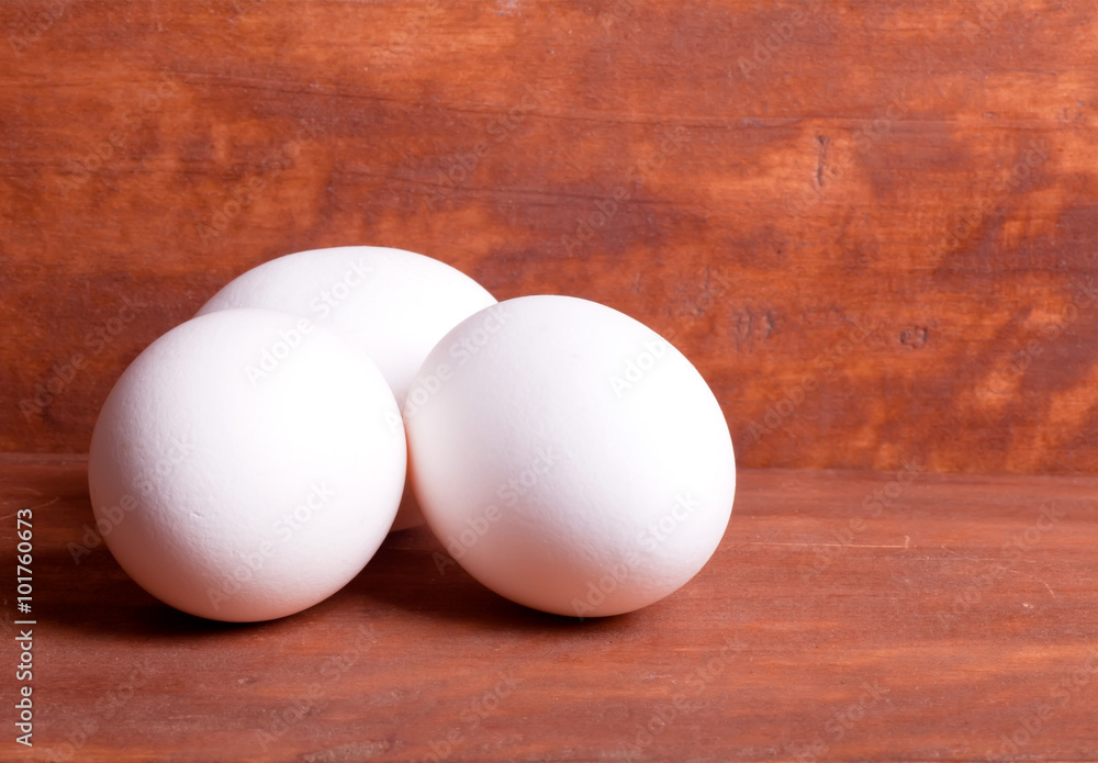 three white eggs on the wooden background