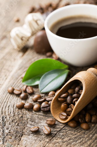 ground coffee in scoop and coffee beans on a wooden background,