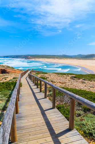 Wooden walkway to Praia do Bordeira beach and beautiful blue sea view, Algarve region, Portugal © pkazmierczak