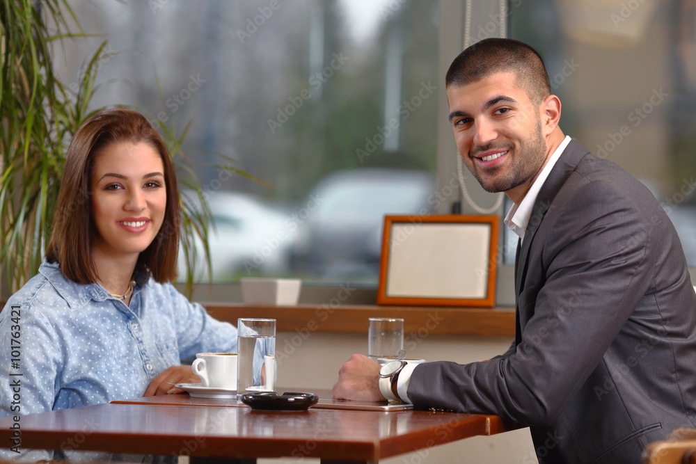 Young business couple sitting in a cafe enjoying their coffee break Young business couple sitting in a cafe enjoying their coffee break