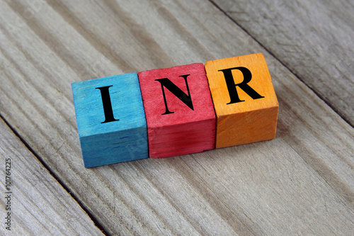 INR (Indian Rupee) sign on colorful wooden cubes