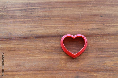 Empty red hollow hearts on a wooden background
