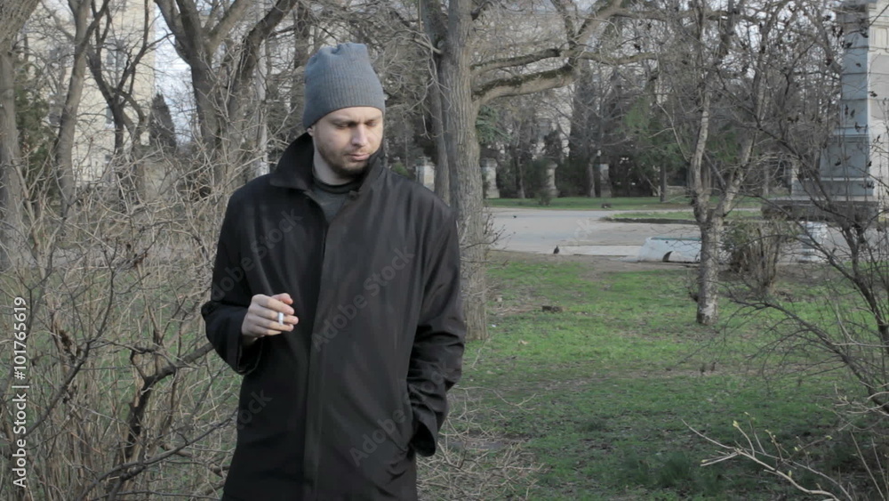 Young guy smokes at a park Young guy smokes at a park
