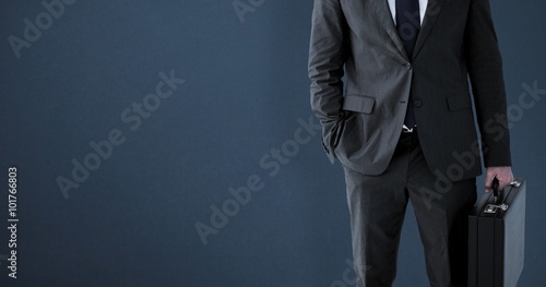 Composite image of businessman standing with his briefcase photo