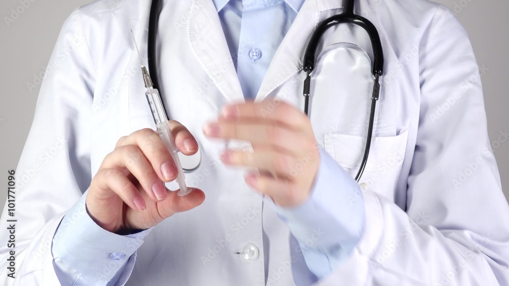 Doctor holding medical syringe and stethoscope, on white Doctor holding medical syringe and stethoscope, on white
