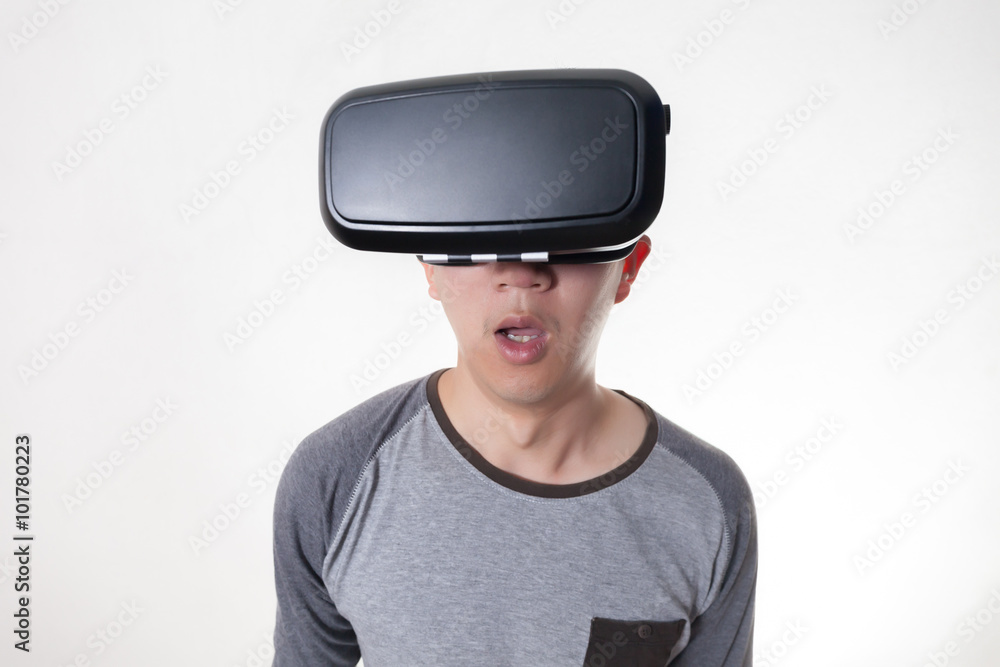 Asian man wearing VR goggle and immersing himself in VR multimedia in white isolated. Asian man wearing VR goggle and immersing himself in VR multimedia in white isolated.