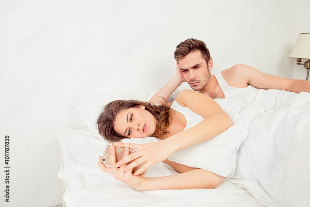Young woman typing message ignoring her boyfriend Young woman typing message ignoring her boyfriend