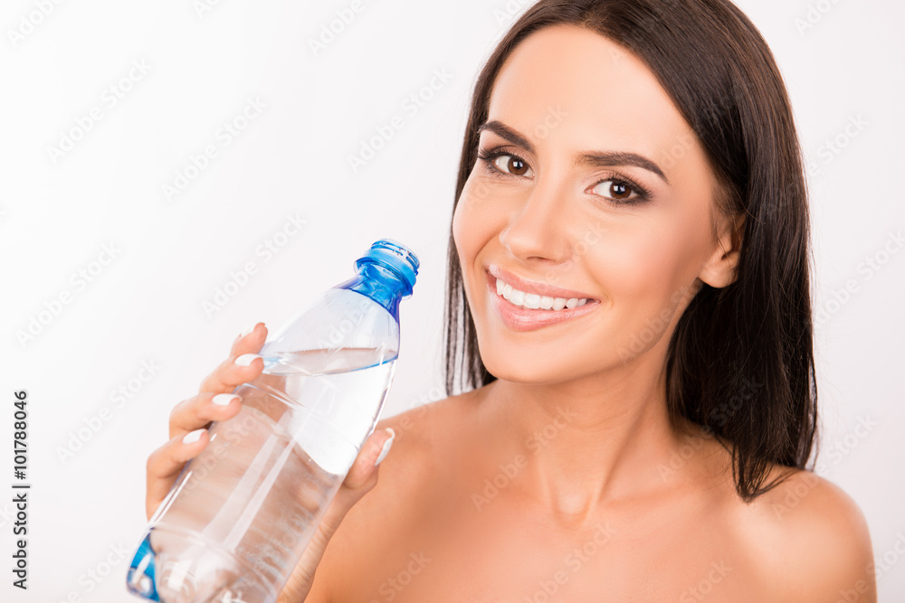 Cheerful young woman holding bottle with fresh water Cheerful young woman holding bottle with fresh water