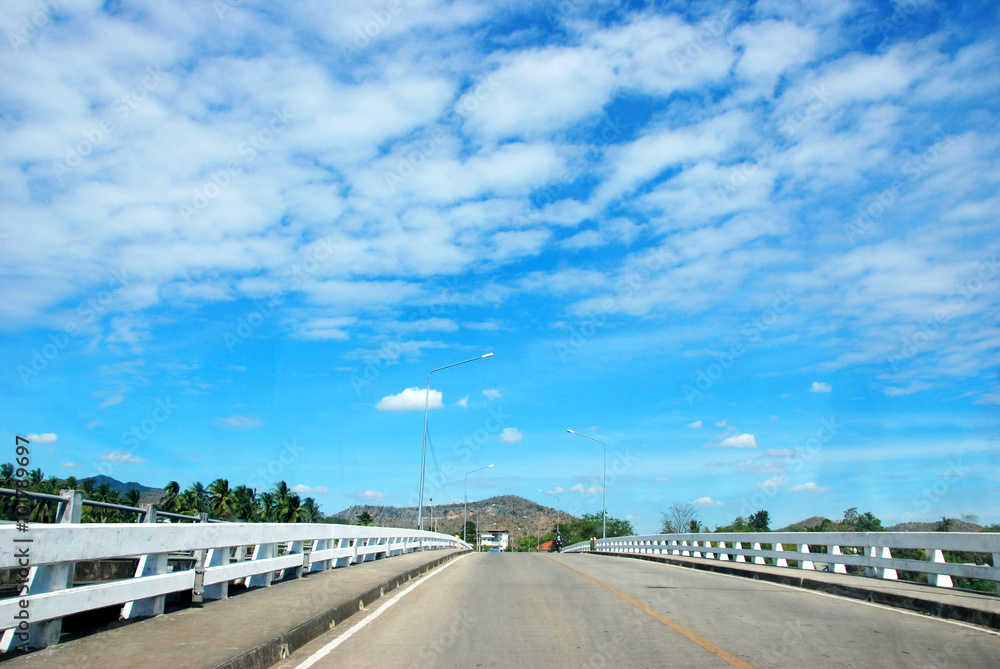 road over dam with blue sky background