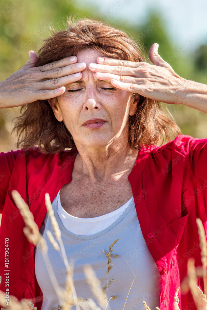 Φωτογραφία outdoors illness - glowing middle aged woman with freckles suffering from headache, massaging her forehead against rhinitis or hay fever reaction,summer daylight