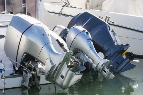 A row of three outboard engines in rest at port