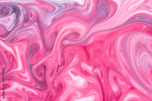 Red and white paint mixing into pink color.