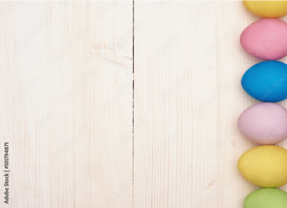 Vertical row of multi colored eggs on the plank Vertical row of multi colored eggs on the plank