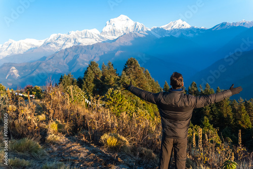 Hiker enjoying the views of the Himalayan mountains at Poon Hill, Nepal photo