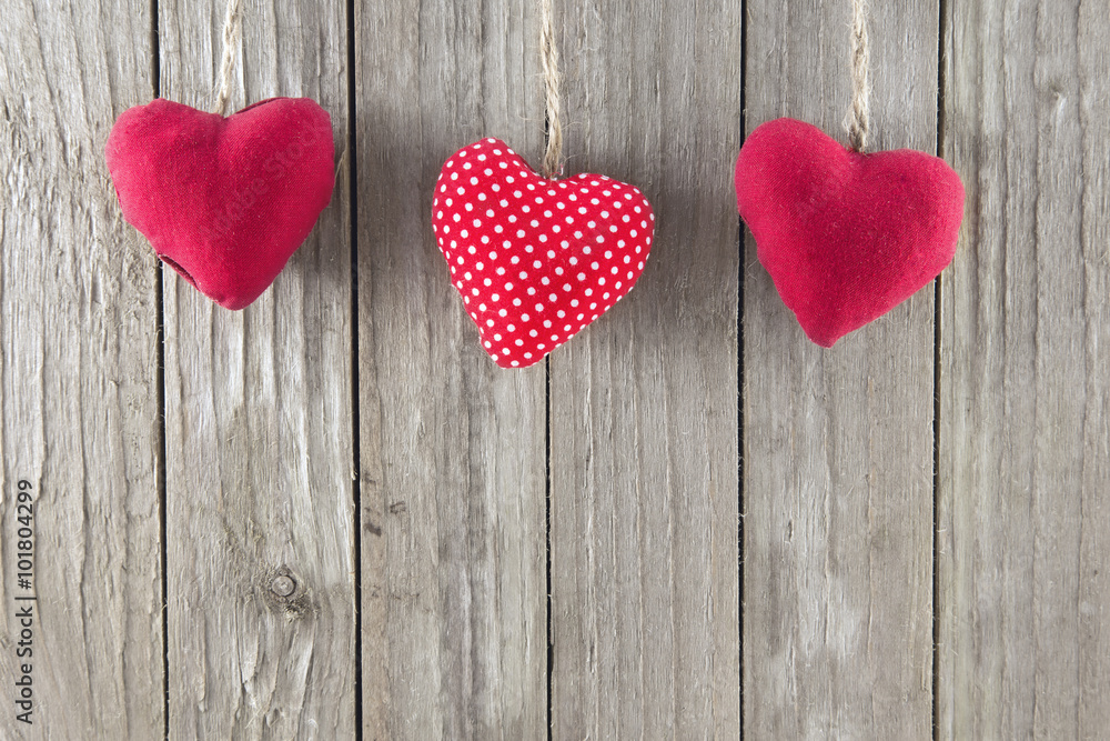 Three red hearts on a wooden background Three red hearts on a wooden background