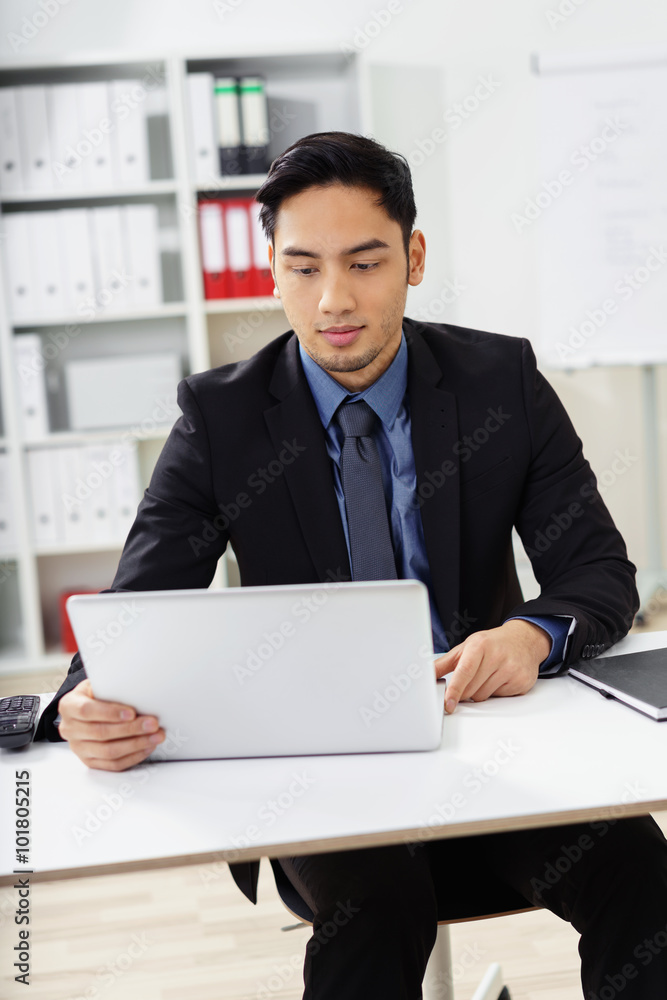 geschäftsmann am arbeitsplatz schaut auf seinen laptop geschäftsmann am arbeitsplatz schaut auf seinen laptop