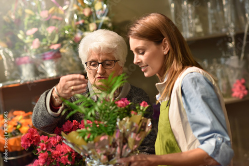 Senior woman in flower shop with florist